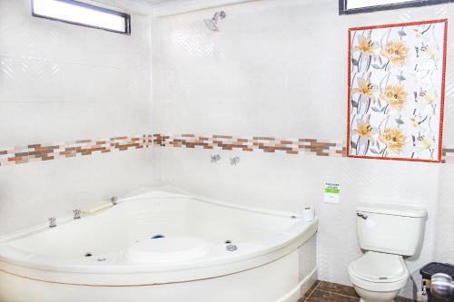a white bathroom with a tub and a toilet at Finca Villa Hermosa in Alcalá