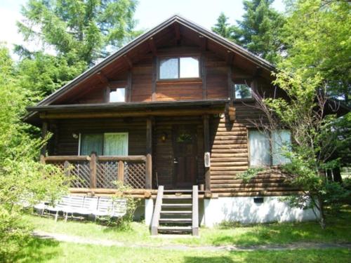 a log cabin with a porch and a door at Karuizawa Sunny Village - Vacation STAY 57957v in Karuizawa
