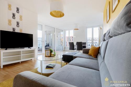 ein Wohnzimmer mit einem Sofa und einem Flachbild-TV in der Unterkunft Pineapple Apartments Dresden Altstadt III - 91 qm - 1x free parking in Dresden
