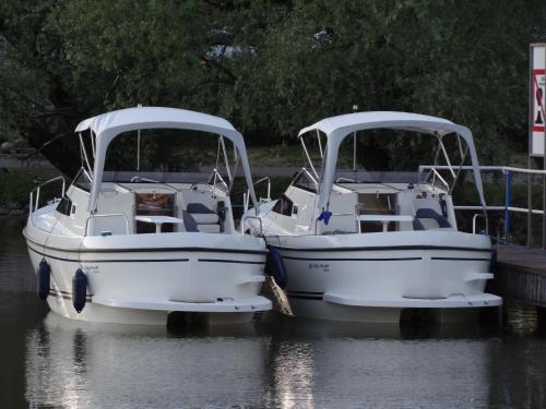 two boats are docked next to each other in the water at Letnisko BAJKA in Iława