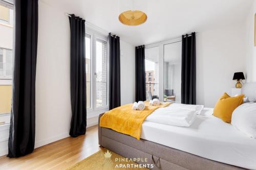 a bedroom with a large bed and large windows at Pineapple Apartments Dresden Altstadt III - 91 qm - 1x free parking in Dresden
