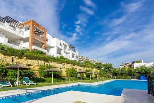 un hôtel avec une piscine en face d'un bâtiment dans l'établissement Los Robles de Los Arqueros golf 3 bedrooms apartment., à Benahavís