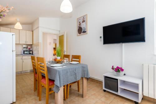 a kitchen and dining room with a table and chairs at Apartment and Rooms Dalmatiko in Vodice