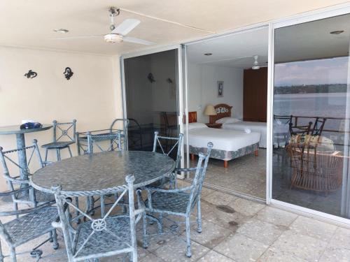 una habitación con mesa y sillas y un dormitorio en Bella casa a la orilla del lago & estacionamiento en Tequesquitengo