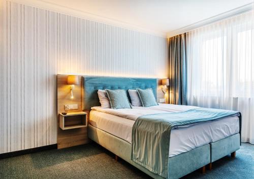 a bedroom with a large bed with a blue headboard at Belmar Park in Władysławowo