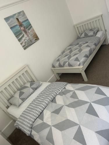 twee bedden naast elkaar in een slaapkamer bij Merton rd serviced accommodation in Walton on the Hill