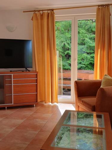 a living room with a flat screen tv and a couch at Dom Kapitana in Mikołajki