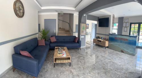 ein Wohnzimmer mit 2 blauen Sofas und einem Tisch in der Unterkunft Kutberk Hotel Kemer in Kemer