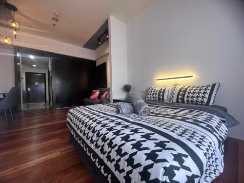 a bedroom with a large bed with a black and white comforter at Resort Suites By Newcityhome in Petaling Jaya