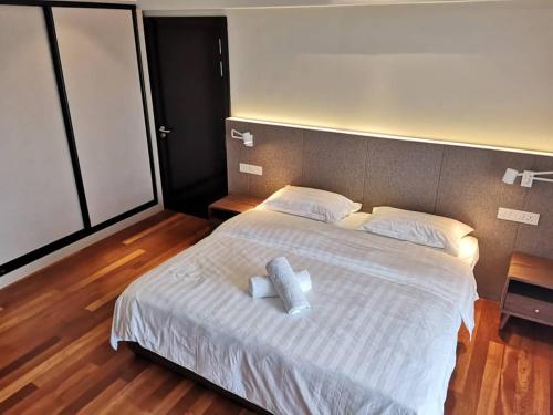 a bedroom with a large white bed with two pillows at Resort Suites By Newcityhome in Petaling Jaya