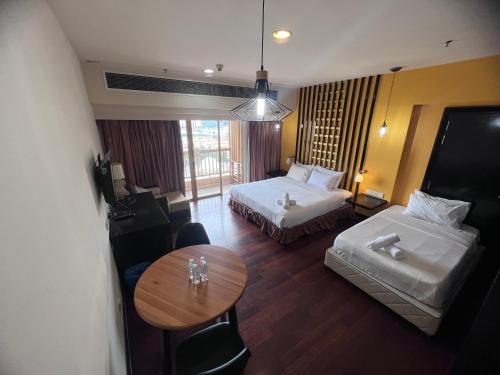 a hotel room with two beds and a table at Resort Suites By Newcityhome in Petaling Jaya