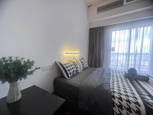 a bedroom with a bed with pillows and a window at Resort Suites By Newcityhome in Petaling Jaya