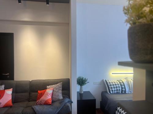 a living room with a couch with colorful pillows at Resort Suites By Newcityhome in Petaling Jaya