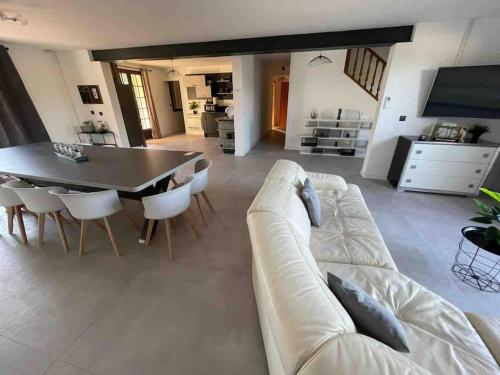 een woonkamer met een bank en een tafel en stoelen bij Bâtisse Provençale in Gréoux-les-Bains
