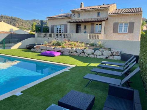 een huis met een zwembad met stoelen en een huis bij Bâtisse Provençale in Gréoux-les-Bains