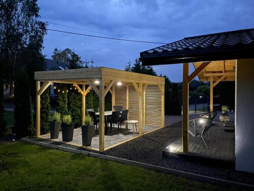 a gazebo with a table in a backyard at RedDoor Zator Lake Houses in Zator