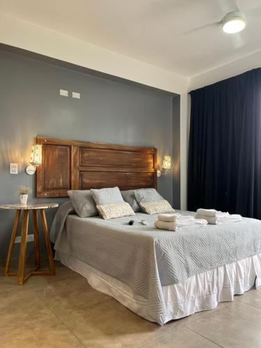 a bedroom with a large bed with a wooden headboard at Plano Vertical in San Miguel de Tucumán