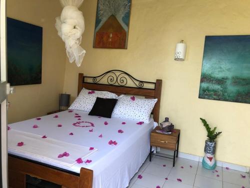 um quarto com uma cama com flores cor-de-rosa em NAFI'0 em Gorée