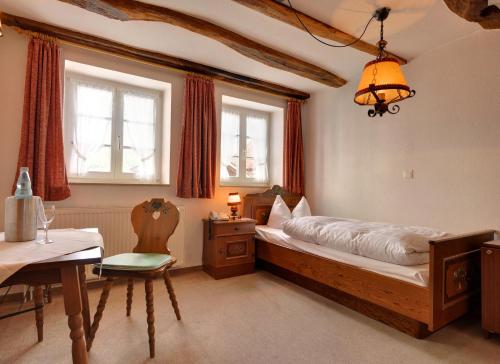 una camera con letto, tavolo e sedie di Hotel Schwalenberger Malkasten a Schieder-Schwalenberg