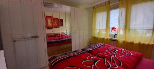 a bedroom with a red bed and a window at Apartment mit Herz in Sondershausen