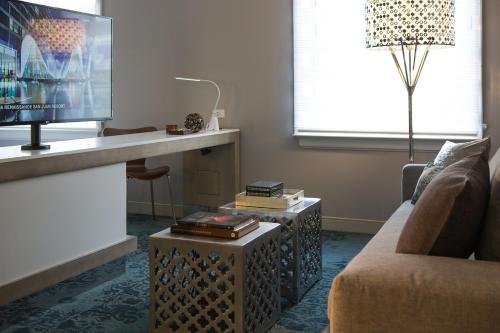 a living room with a couch and a table with a tv at Renaissance Albany Hotel in Albany