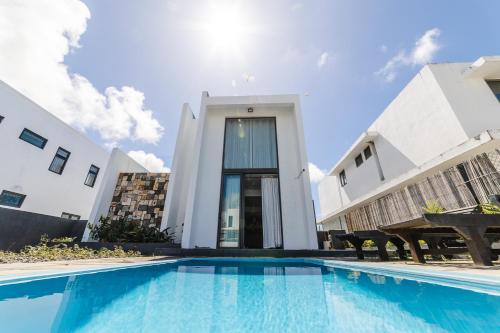 a villa with a swimming pool in front of a building at Viccos Villa - Brand New Villa in Trou d'Eau Douce in Trou dʼ Eau Douce