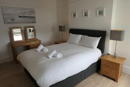 a bedroom with a large bed with two pillows on it at Spacious first floor family flat, Sea view in Torquay