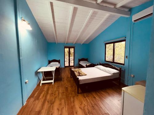 um quarto com duas camas e paredes azuis em Favela Chic Room em Durrës