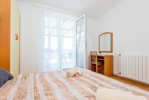 a bedroom with a bed with a desk and a mirror at Apartment and Rooms Dalmatiko in Vodice