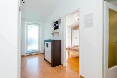 a room with a hallway with a table and a window at Apartment and Rooms Dalmatiko in Vodice