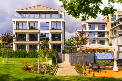 an apartment building with a garden in front of it at Open Sea Panorama Residence in Obzor