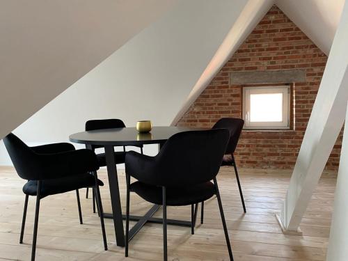 a table and chairs in a room with a brick wall at Het Generaaltje in Hasselt