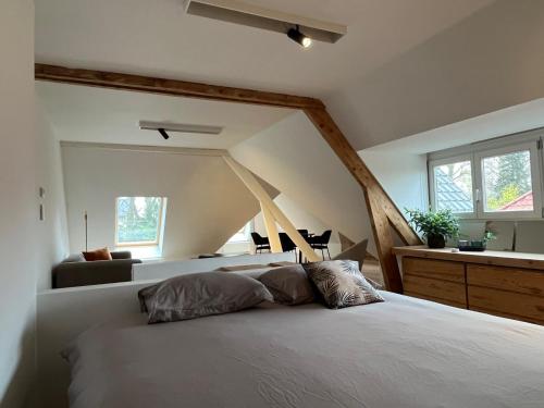 1 dormitorio con cama, sofá y ventanas en Het Generaaltje en Hasselt