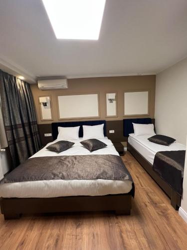 a bedroom with two beds and a skylight at Amber Hotel in Sarajevo