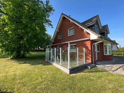 a house with a greenhouse on the side of it at Wieckblick Krummin 17b in Krummin