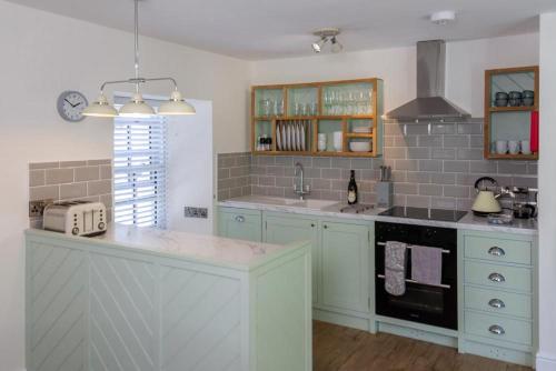 uma cozinha com armários azuis e uma bancada em Skerrow em New Galloway