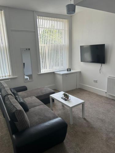 a living room with a couch and a table at Merton rd serviced accommodation in Walton on the Hill