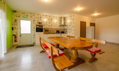a kitchen with a wooden table and two chairs at Le grand clos in Meurville