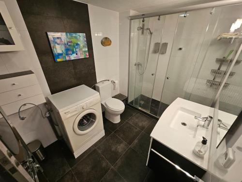 uma casa de banho com uma máquina de lavar roupa e um lavatório em Torres Blancas (Beach & Golf) em Alicante