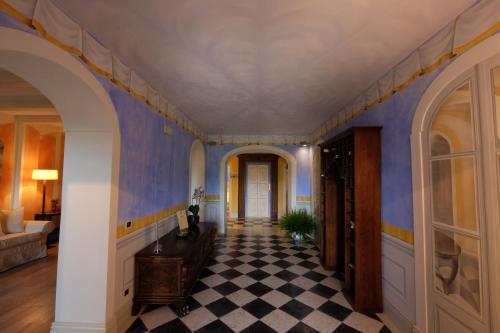 a hallway with blue walls and a checkered floor at Park Hotel Villa Belvedere in Cannobio