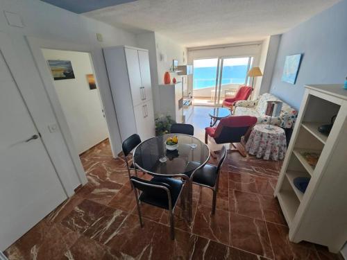 uma sala de estar com uma mesa de vidro e cadeiras em Torres Blancas (Beach & Golf) em Alicante