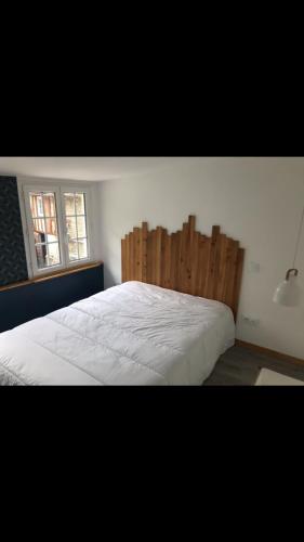 una camera con un grande letto con testiera in legno di Le 30 a Canteleu