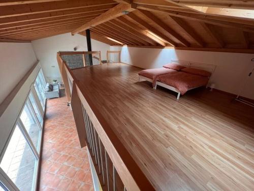 een grote kamer met een bed en een houten vloer bij Un sogno nella natura in Agarone