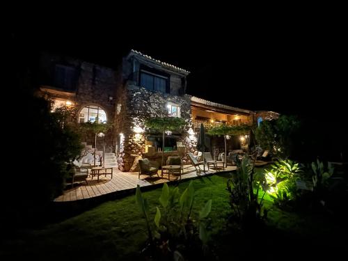 a house with a yard at night with lights at Hôtel Ambassador Palombaggia in Porto-Vecchio