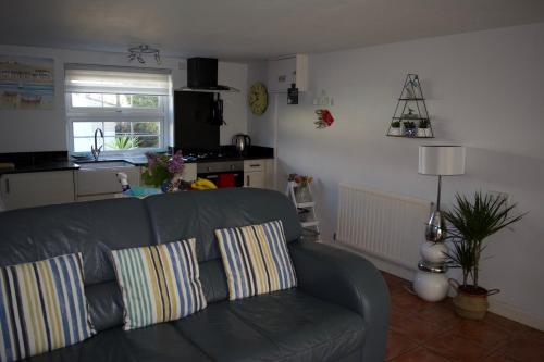 ein Wohnzimmer mit Couch und Küche in der Unterkunft Coach House. Falcon Mews in Bude