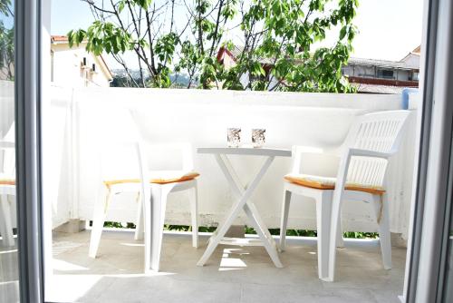 - Balcón con mesa blanca y sillas en Guest house Tina, en Rab