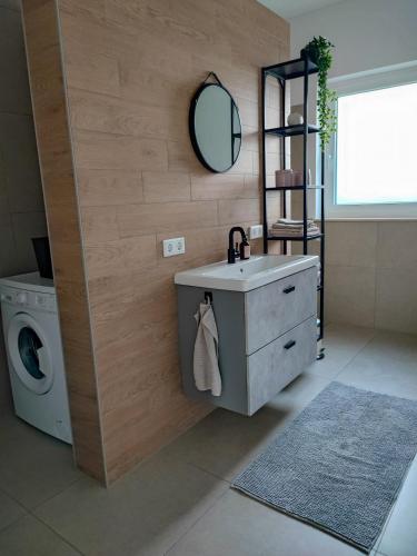 a bathroom with a sink and a washing machine at Ferienwohnung Magel in Waldsolms