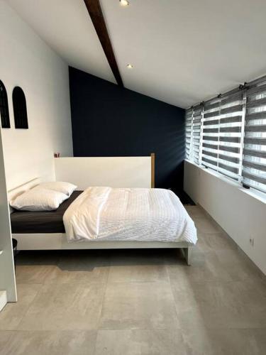 1 dormitorio con cama y pared azul en Appartement Duplex avec jardin, en Ingersheim