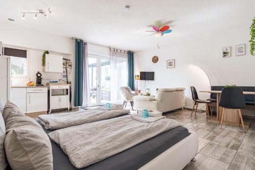 a living room with three beds and a kitchen at Eifel-Apartments Orsfeld in Orsfeld