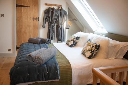 Un dormitorio con una cama con almohadas. en The Forge - Beautiful Contemporary Barn - Hot Tub en Bridgnorth
